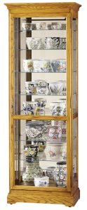 Light wooden curio cabinet with different sizes and colors of pots and vases