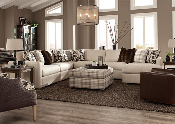 white Sectional with plaid ottoman and multi pattern pillows