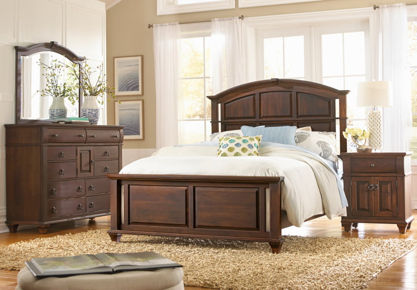 Dark wooden bedroom set with dresser and mirror, bed frame, and bedside table