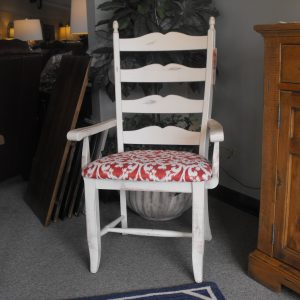 White wooden armchair with red and white patterned cushion