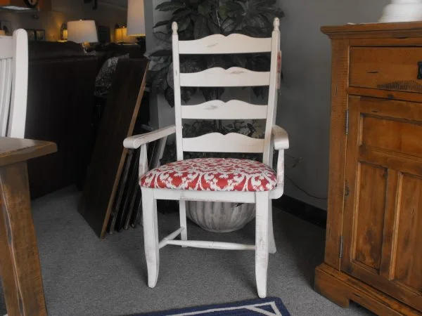 White wooden armchair with red and white patterned cushion