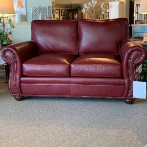 red leather loveseat with metal detailing