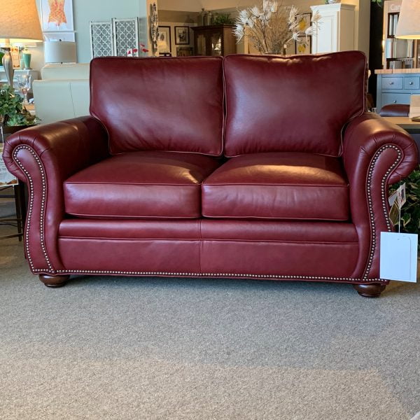 red leather loveseat with metal detailing