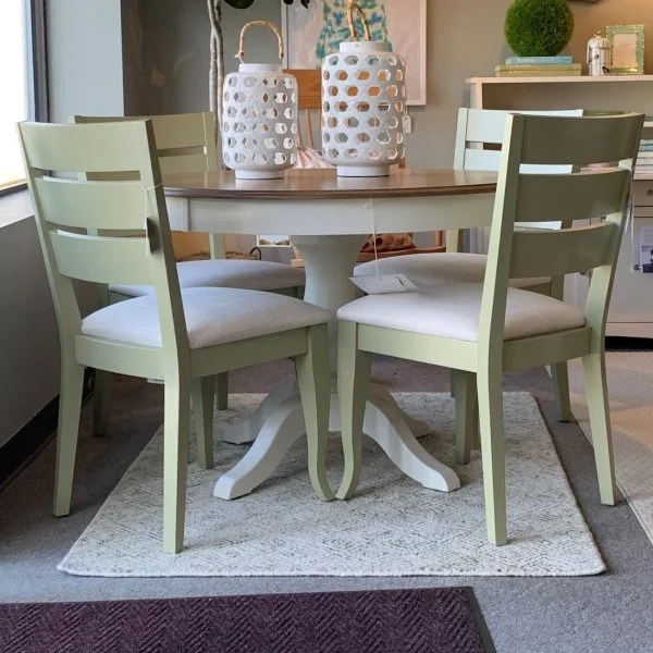 white and brown round table and 4 green seats with white cushions