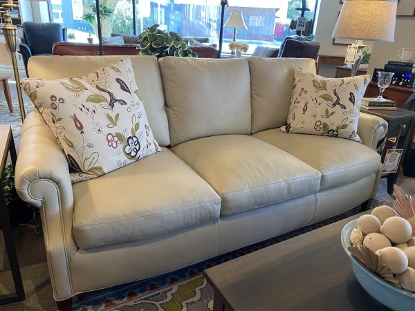 white leather couch with two patterned pillow