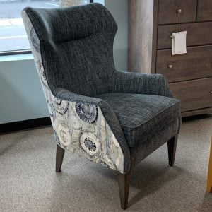 grey fabric armchair with circular designs on it's arm and brown wooden legs
